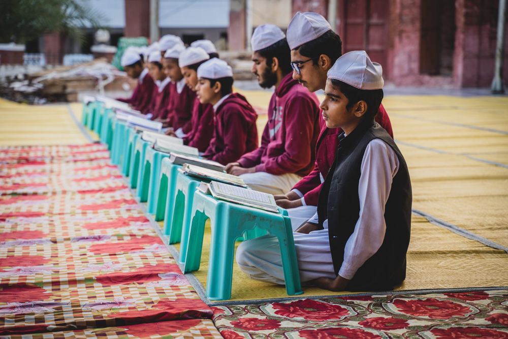 Students read the Qur'an at low desks