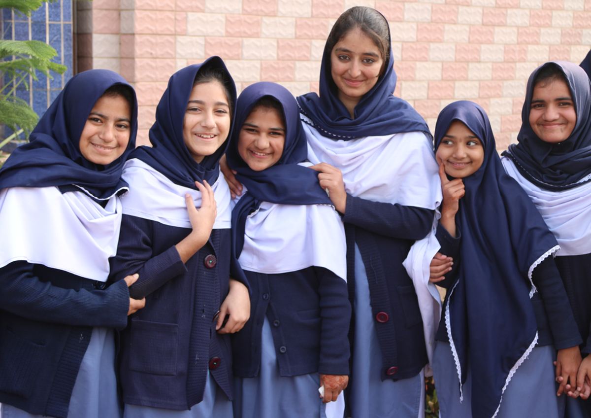A group of schoolgirls in uniform pose together