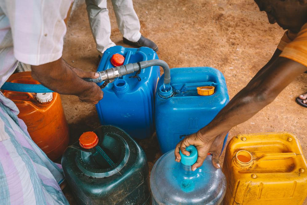 Water containers are filled at a tap